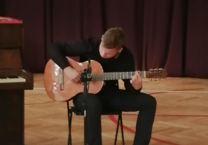 Uczeń grający na gitarze